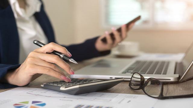 Close up of female accountant or banker making calculations. Savings, finances and economy concept